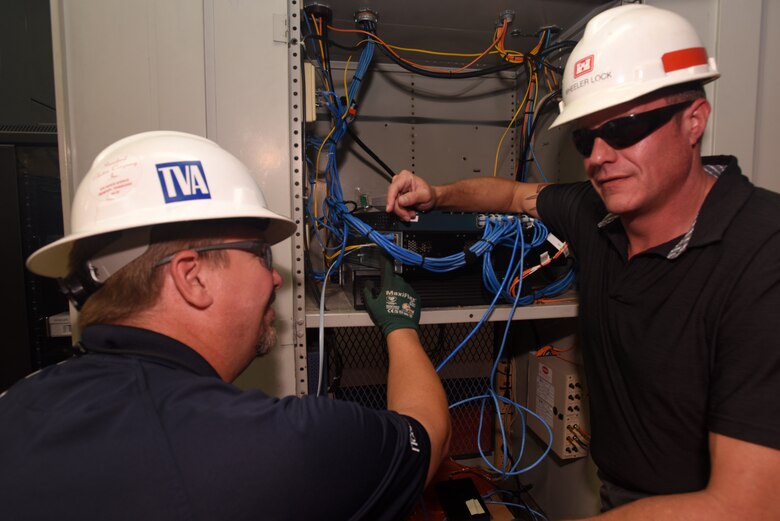 Rich Ellis (Left), field engineer with the Tennessee Valley Authority Region 1 Information Technology Field Services, and Bradley Gatewood, U.S. Army Corps of Engineers Nashville District Information Technology chief, make the final fiber optic connection to Joe Wheeler Lock, increasing bandwidth and data transmission speeds. The Nashville District operates and maintains the lock at the TVA project in Rogersville, Ala. The two agencies are partnering to establish fiber optic connections at all 10 lock project sites on the Tennessee River and Clinch River. (USACE Photo