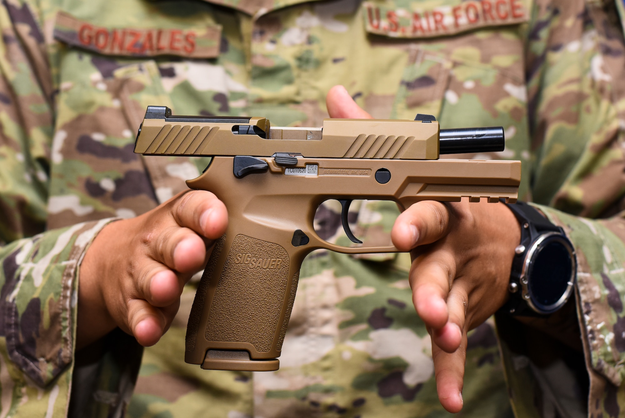 Staff Sgt. Will Gonzales, 36th Security Forces Squadron armory NCO in charge, displays a Sig Sauer M18 pistol on Andersen Air Force Base, Guam, Aug. 26, 2019.