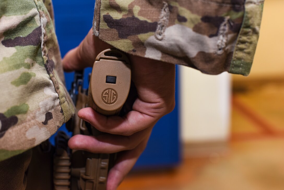 Staff Sgt. Will Gonzales, 36th Security Forces Squadron armory NCO in charge, holsters a Sig Sauer M18 pistol on Andersen Air Force Base, Guam, Aug. 26, 2019.