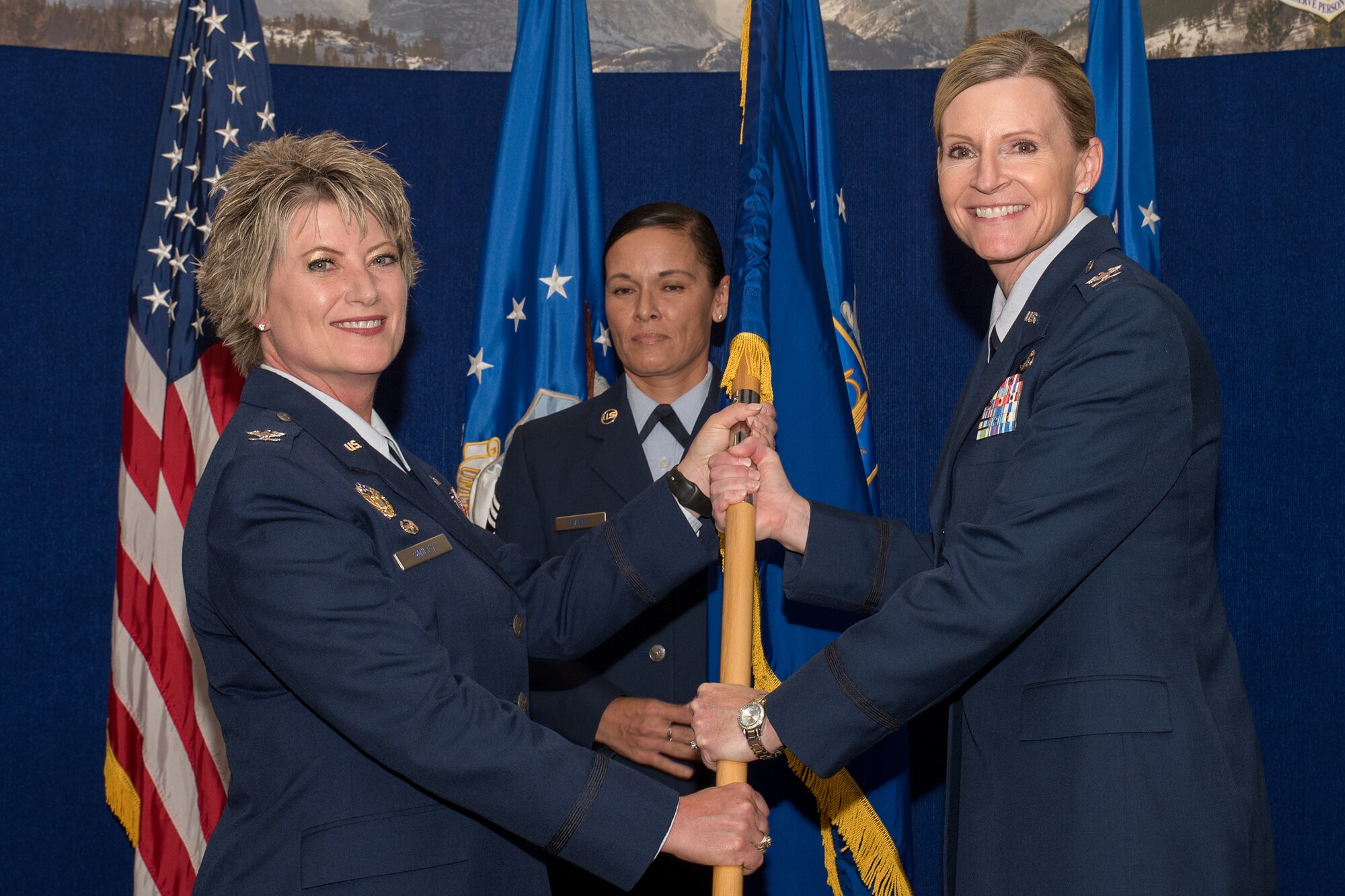 Col. Amy J. Boehle (right), Headquarters Individual Reservist Readiness and Integration Organization (HQ RIO),commander, receives the guidon from Col. Kelli B. Smiley (left),  Commander Air Reserve Personnel Center, during an assumption of command ceremony Aug. 28, 2019, at Buckley Air Force Base, Colo. As the HQ RIO commander, Boehle is responsible for seamlessly integrating over 8,000 wartime-ready Individual Reserve forces in more than 50 MAJCOMs, COCOMs, and government agencies to meet Air Force and Combatant Commander requirements. (U.S. Air Force photo by Master Sgt. Eric Amidon)