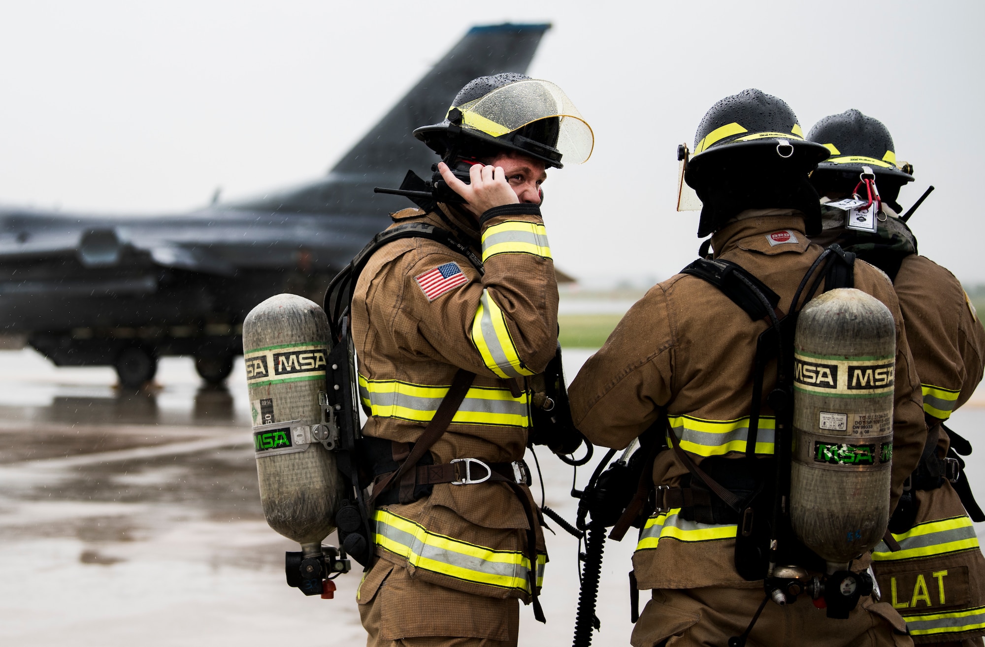 U.S. Air Force Airmen from the 8th Civil Engineer Squadron fire department talk on their radios during training at Kunsan Air Base, Republic of Korea, Aug. 27, 2019. The training gave first responders and maintenance professionals the opportunity to respond to a U.S. Air Force F-16 Fighting Falcon emergency landing. (U.S. Air Force photo by Senior Airman Stefan Alvarez)