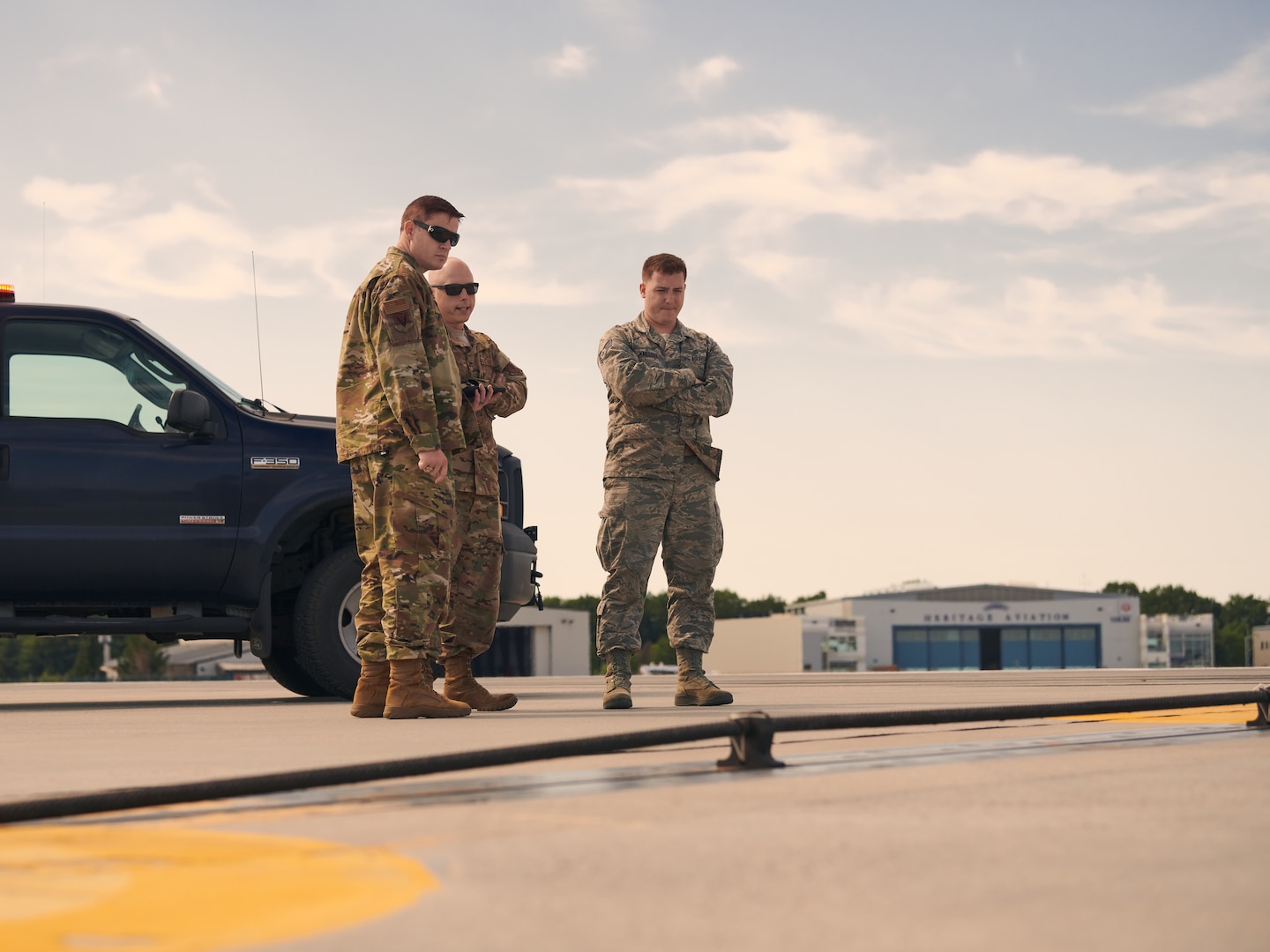 U.S. Air Force Master Sgt. Darren Adams, center, and Staff Sgt. Joseph Mailloux, right, both assigned to the airfield management section of the 158th Operations Group, 158th Fighter Wing, Vermont Air National Guard, inspect an arresting cable on the flightline at the Burlington Air National Guard Base, Vt., Aug. 3, 2019. This arresting cable can quickly be raised on the runway and grab onto a hook attached to fighter aircraft to help it stop in the event of an emergency landing. (U.S. Air National Guard photo by Tech. Sgt. Ryan Campbell)