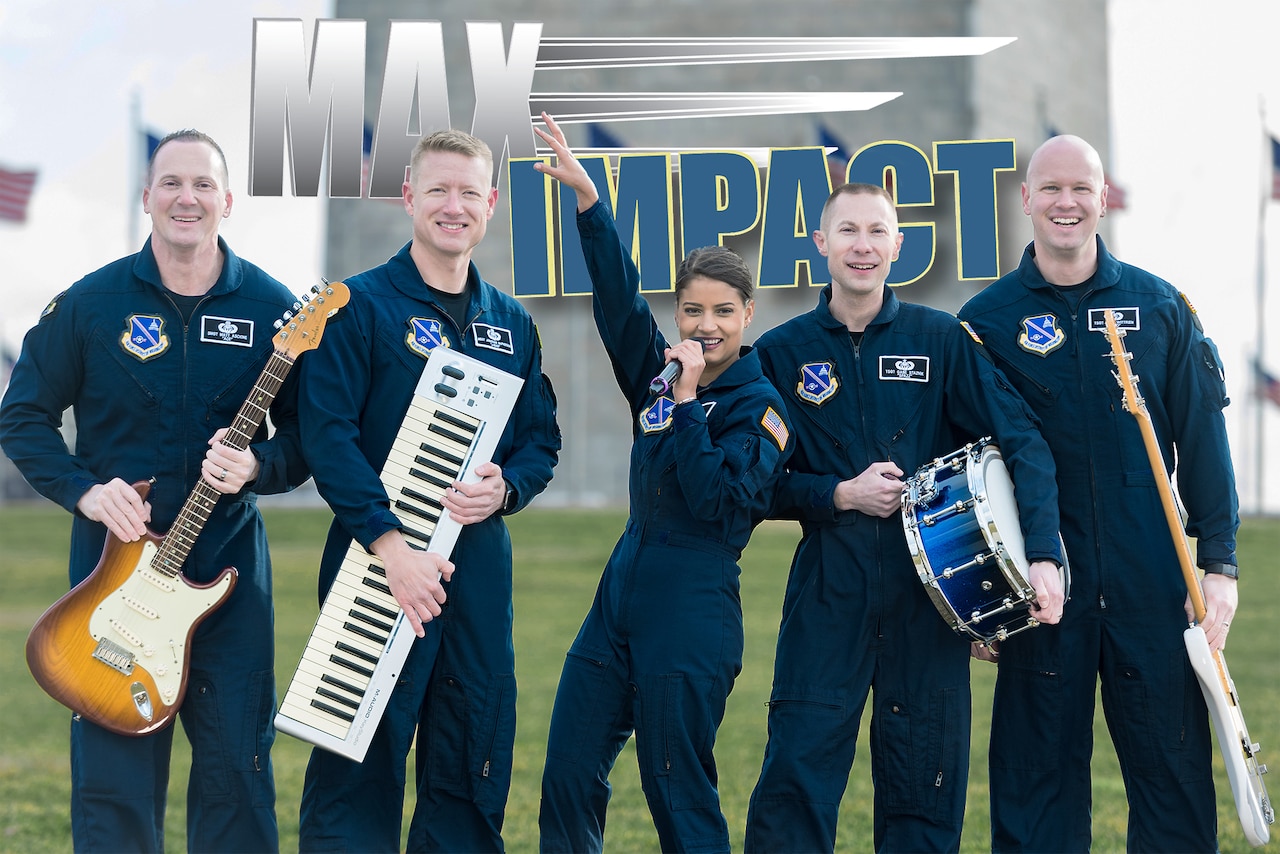 Five airmen wearing flight suits who make up the rock band Max Impact pose on a field with their respective instruments.