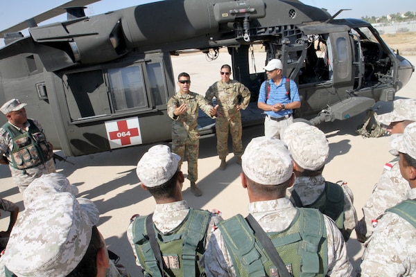 U.S. Army Sgt. Ignacio Aparicio, center, crew chief, Golf Company, 5th Battalion, 159th Aviation Regiment, talks to members of Jordan Armed Forces’ 7th Mechanized Infantry Battalion about hand signals and casualty loading procedures during medical evacuation training in preparation for exercise Eager Lion 2019, Aug. 21, 2019. This multinational exercise is U.S. Central Command’s premiere exercise in the Levant region and is a major training event that provides U.S. forces, Jordan Armed Forces and 28 other participating nations the opportunity to improve their collective ability to plan and operate in a coalition-type environment. (U.S. Army Reserve photo by Sgt. Zach Mott)