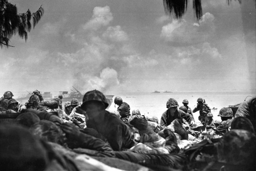 Marines move inland from the sea during battle.
