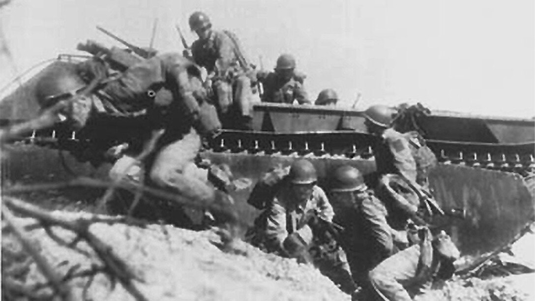 Troops wade onto beach.