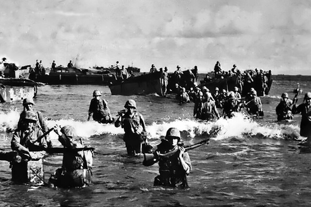 Marines wade onto beach.