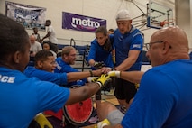Participants of the Air Force Wounded Warriors program get pumped up before a wheelchair rugby match against a team of volunteers during the AFW2 CARE event, Aug. 23, 2019 at Scott Air Force Base, Ill. Throughout the week, participants also got a chance to compete in archery, powerlifting, sitting volleyball and wheelchair basketball.