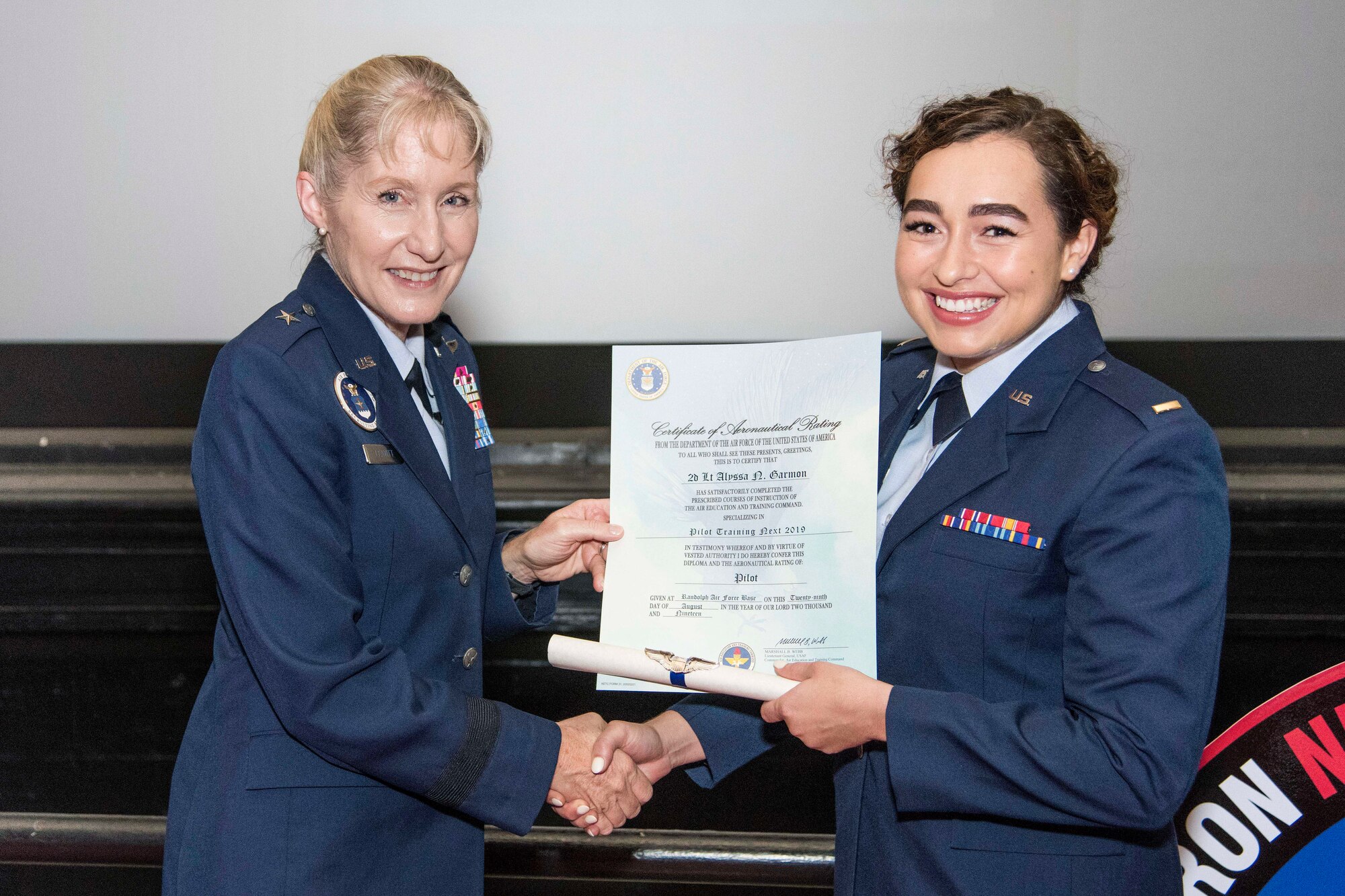 Brig. Gen. Jeannie Leavitt, Air Force Recruiting Service commander, presents 2nd Lt. Alyssa Garmon her certificate of aeronautical rating during Pilot Training Next graduation ceremony August 29, 2019, at Joint Base San Antonio-Randolph, Texas. The graduates, which included two Air National Guard students, were selected to fly airframes including the F-35 Lightning II, F-15E Strike Eagle, F-16 Fighting Falcon, C-17 Globemaster III, C-130 Hercules, EC-130 Compass Call, C-5 Galaxy, B-2 Spirit, C-146A Wolfhound, and the T-6 Texan II. (U.S. Air Force photo by Sean M. Worrell)