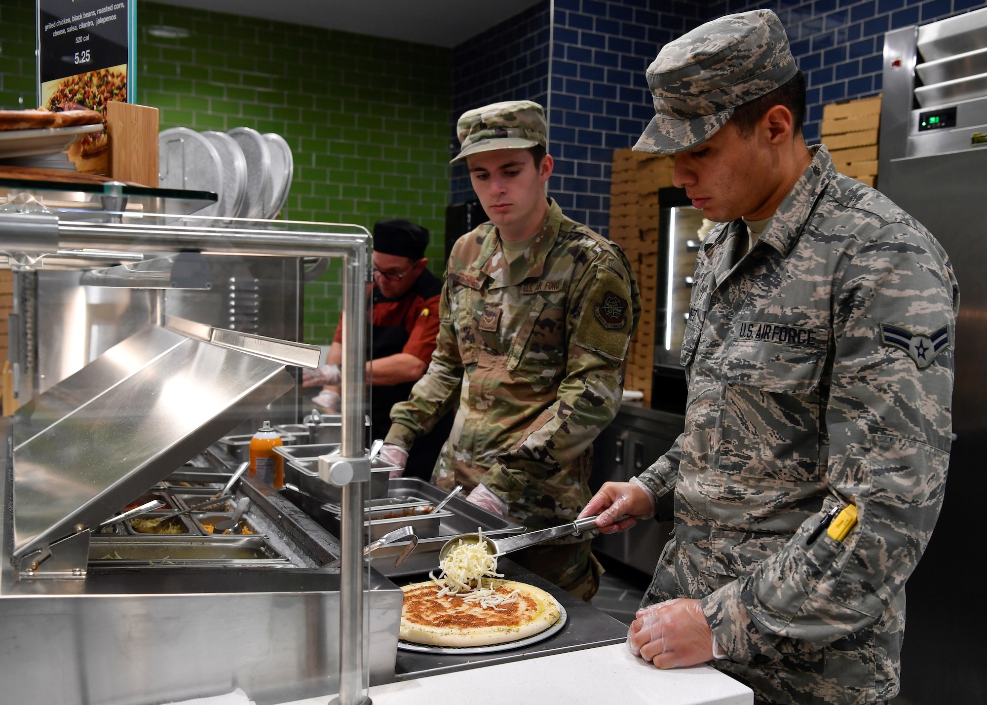 U.S. Air Force Airman 1st Class Jose Ramirez and U.S. Air Force Airman 1st Class Brett Tischner, 87th Force Support Squadron service’s Airmen, make pizza for customers during the re-opening of the Halvorsen Hall Dining Facility on Joint Base McGuire-Dix-Lakehurst, New Jersey, Aug. 27, 2019. New additions to the DFAC include a pizza bar, sub sandwiches and a salad bar priced lower than food options regularly found outside of Joint Base MDL. An additional change includes utilization of the DFAC for all Joint Base MDL community members.