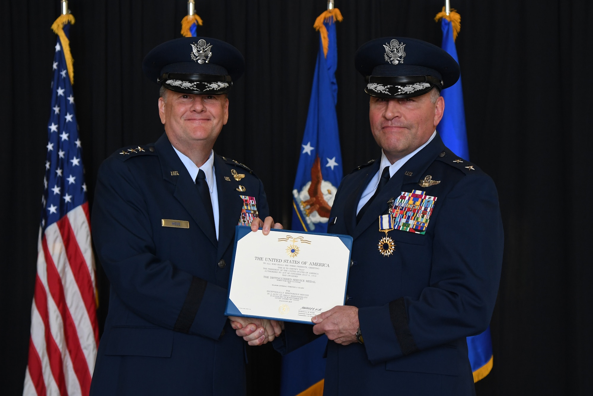 U.S. Air Force Lt. Gen. Brad Webb, commander of Air Education and Training Command, presents the Distinguished Service Medal certificate to Maj. Gen. Timothy Leahy, Second Air Force commander, during the Second Air Force change of command ceremony on Keesler Air Force Base, Mississippi, Aug. 29, 2019. The ceremony is a symbol of command being exchanged from one commander to the next. Leahy relinquished command of the Second Air Force to Maj. Gen. Andrea Tullos. (U.S. Air Force photo by Kemberly Groue)