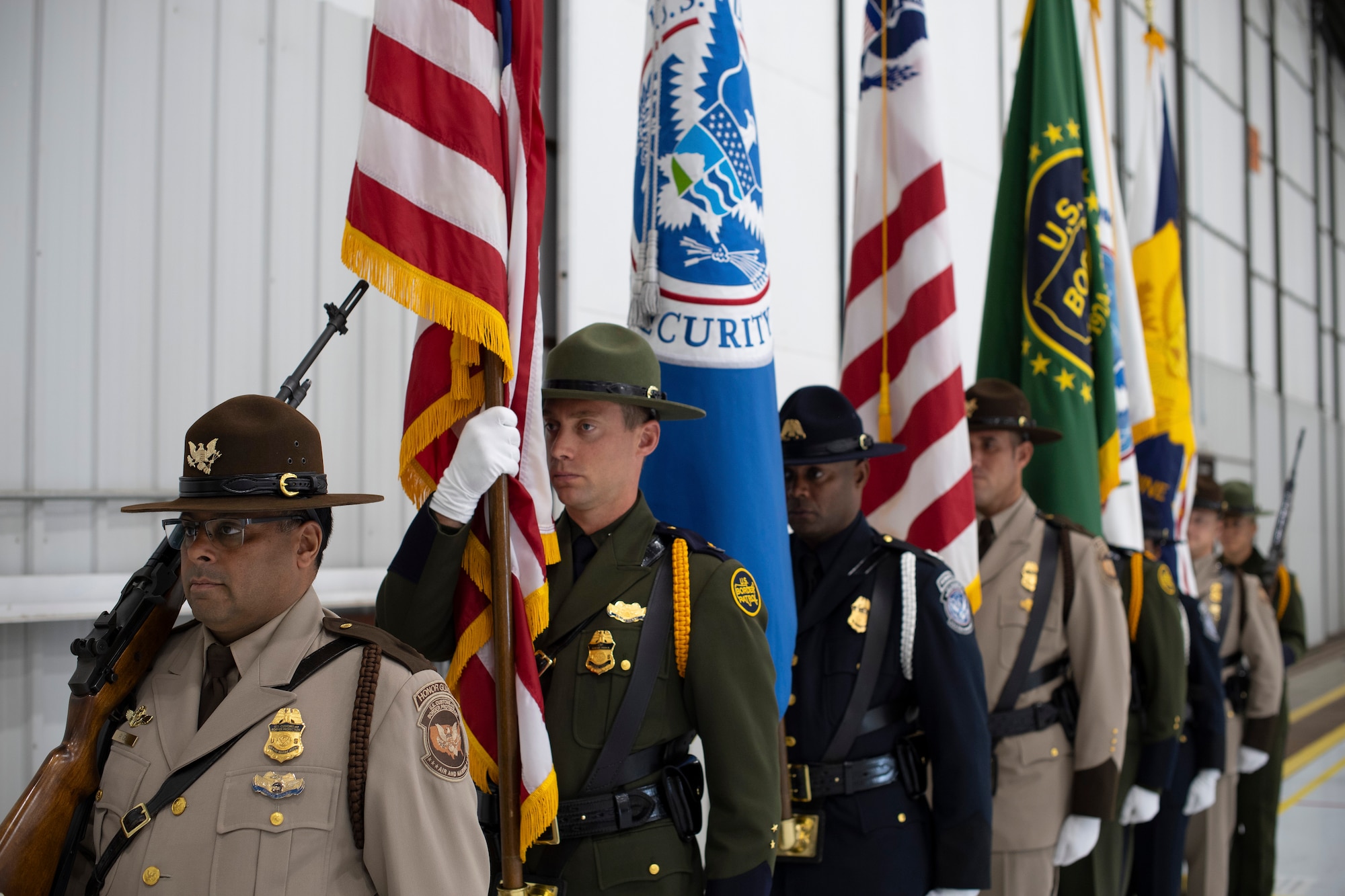 Members of the U.S. Customs and Border Protection Honor Guard stand ready to present their flags during a ceremony August 28, 2019, on Grand Forks Air Force Base, North Dakota. The ceremony celebrated a newly-renovated facility on base which will house manned and unmanned CBP aircraft assigned to the National Air and Security Operations Center, Grand Forks. (U.S. Air Force photo by Senior Airman Elora J. Martinez)