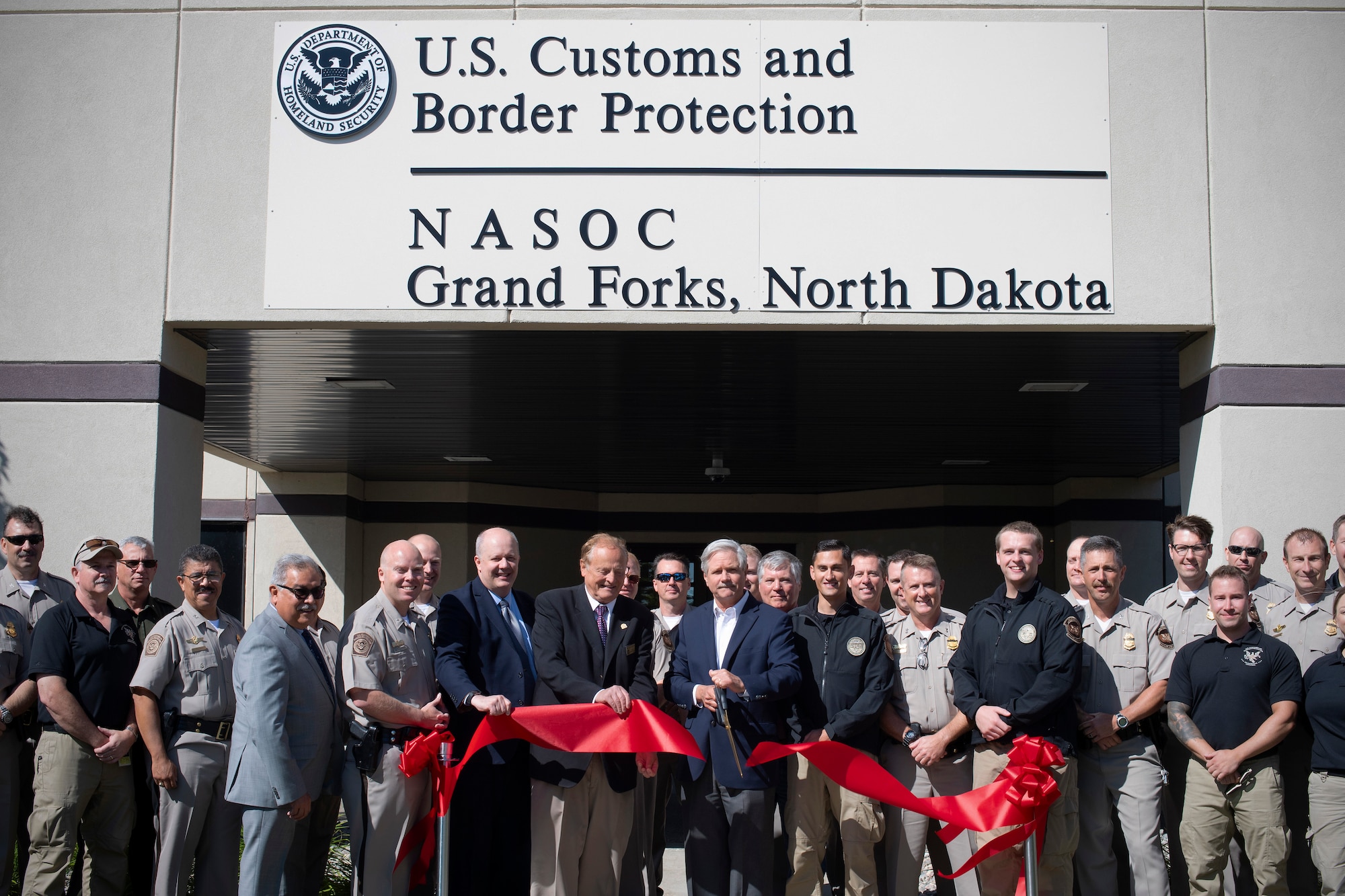North Dakota Senator John Hoeven officiates the opening of U.S. Customs and Border Protection’s newly-renovated National Air Security Operations Center by cutting a ceremonial ribbon August 28, 2019, on Grand Forks Air Force Base, North Dakota. The NASOC will provide initial and recurrent training for unmanned aerial system pilots with CBP. (U.S. Air Force photo by Senior Airman Elora J. Martinez)