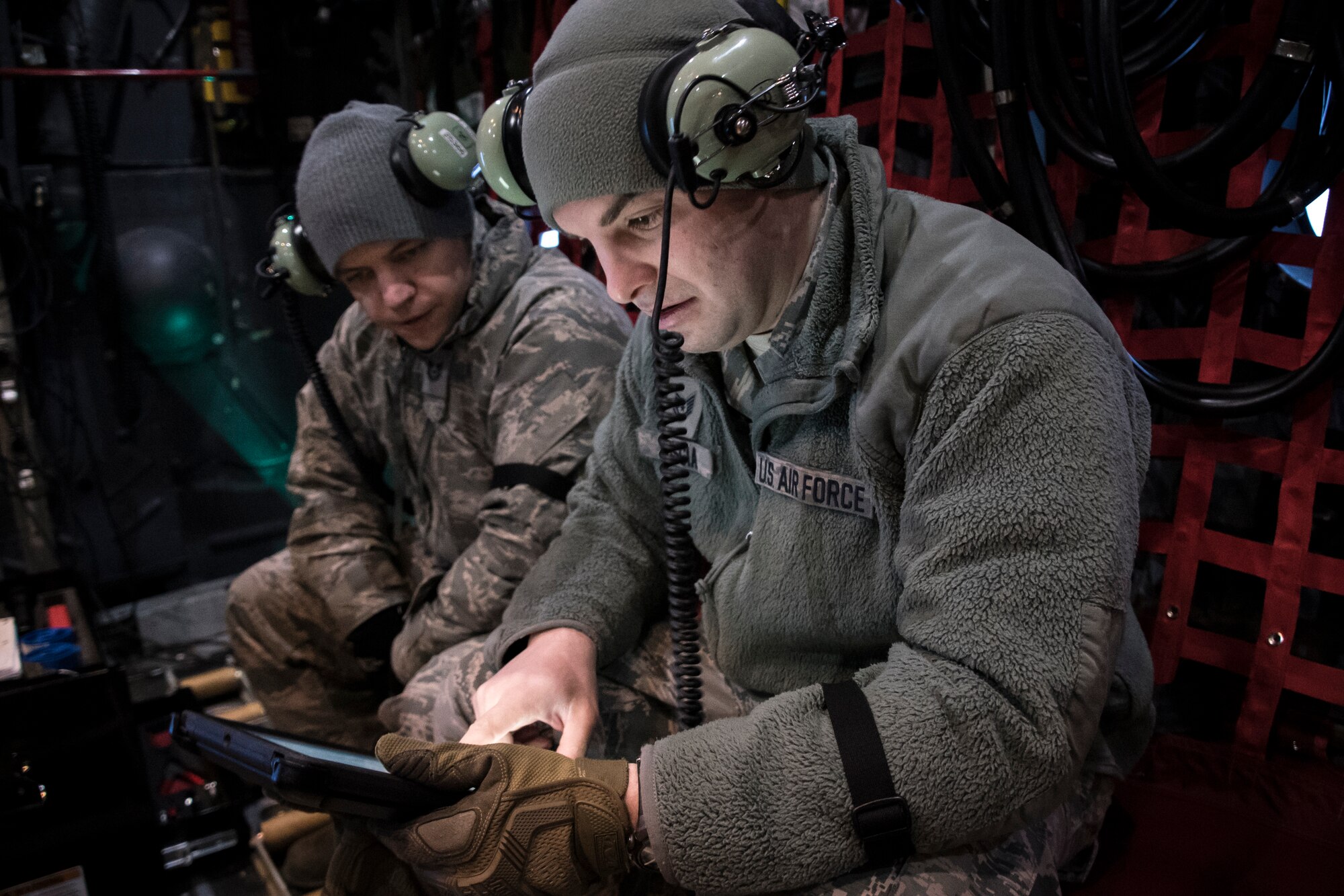 A photo of two military members viewing information on a tablet.