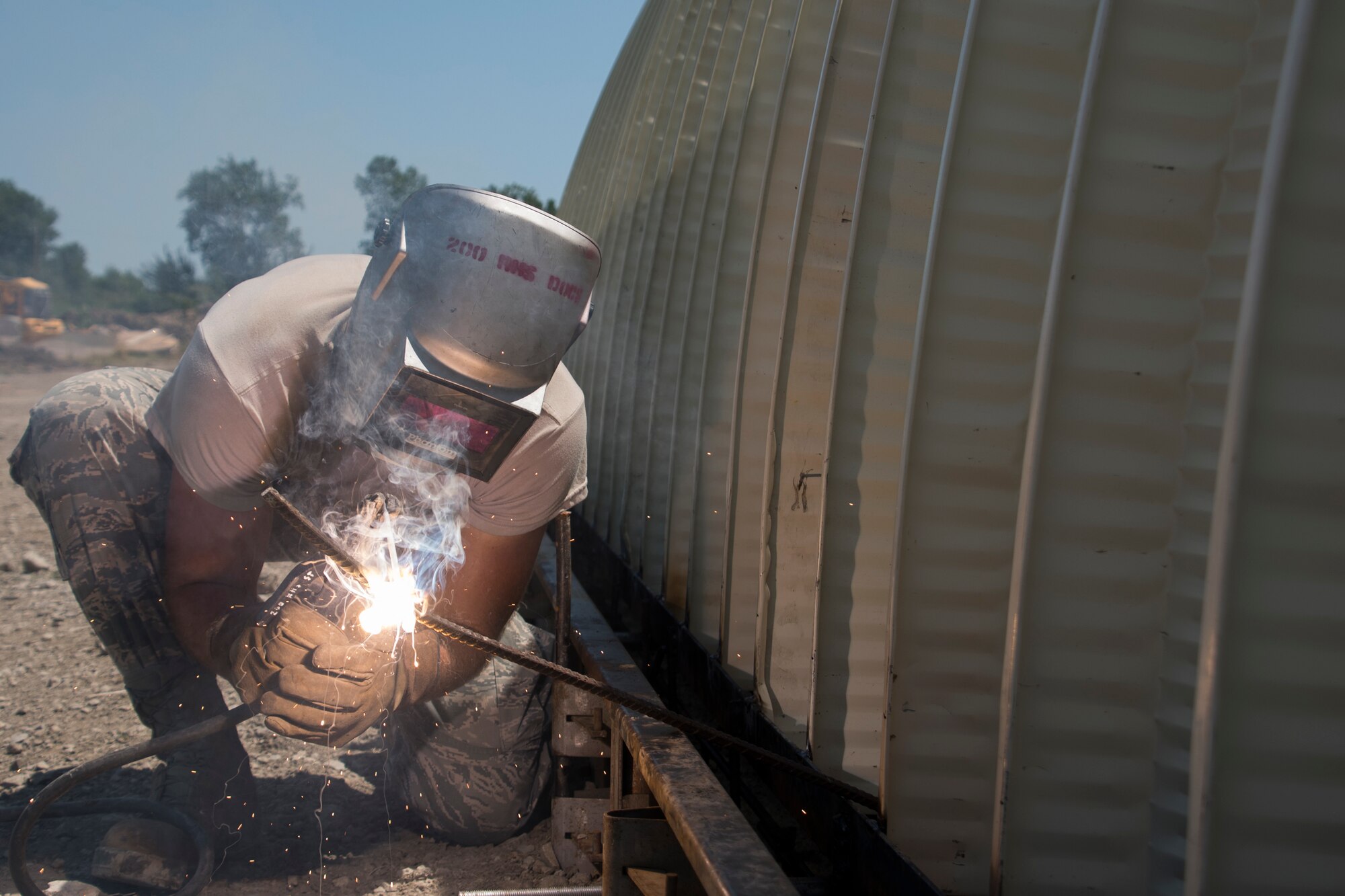 A photo of a military member using welding equipment on a military building.