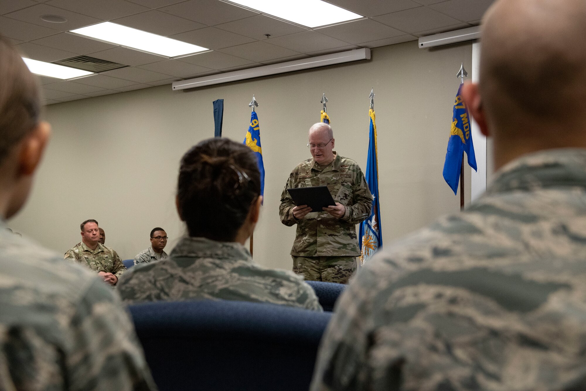 U.S. Air Force Col. Howard Givens, 97th Medical Group commander reads a proclamation to honor the restructuring of the 97th MDG,