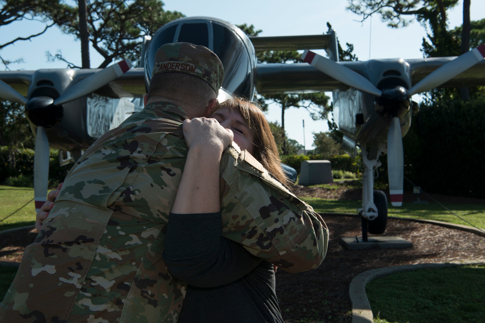 Two people sharing a hug in an airpark.