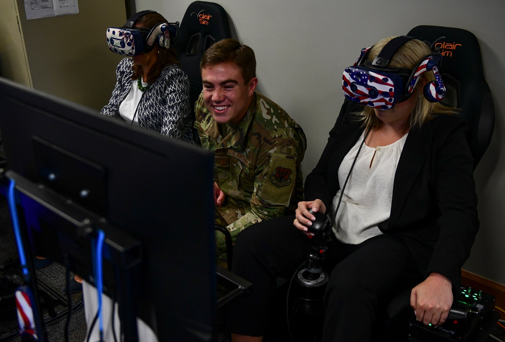 2nd Lt. Johnny Griffith, 4th Training Squadron virtual reality innovation manager, shows distinguished visitors how to fly an F-15E Strike Eagle while using a VR setup at Seymour Johnson Air Force Base, North Carolina, August 29, 2019. The DV’s were part of a tour for North Carolina Governor Roy Cooper, and saw some of the innovative techniques the base is using to train its aircrew. (U.S. Air Force photo by Senior Airman Kenneth Boyton)