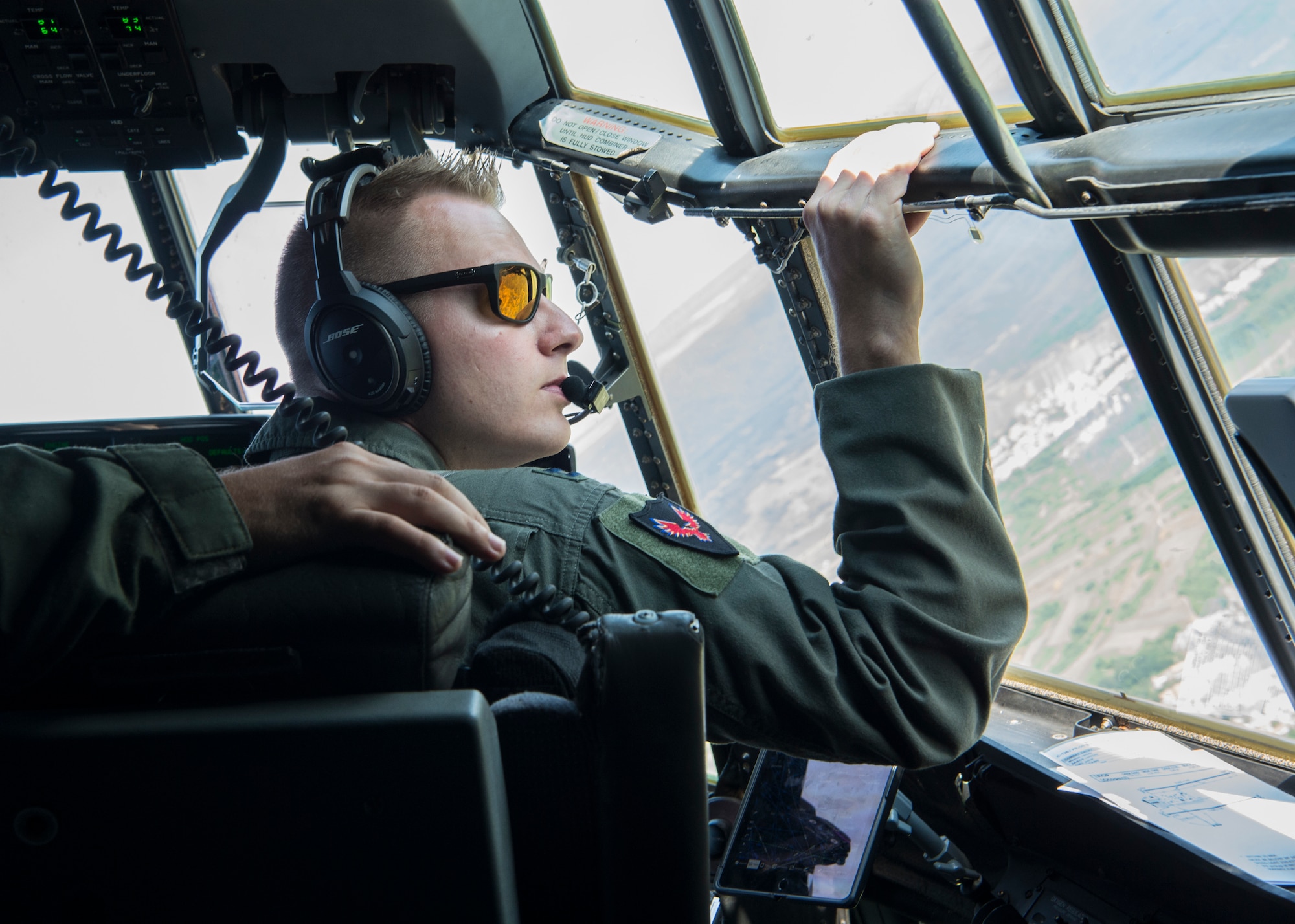 U.S. Air Force Capt. Dan Hill, 37th Airlift Squadron C-130J Super Hercules pilot, looks out his window while copilot over Romania, Aug. 21, 2019. Romanian and U.S. Air Force members participated in exercise Carpathian Fall 2019 allowing U.S. military members stationed at Ramstein Air Base, Germany, the opportunity to attain certifications and training that isn’t otherwise possible in Germany. (U.S. Air Force photo by Staff Sgt. Kirby Turbak)