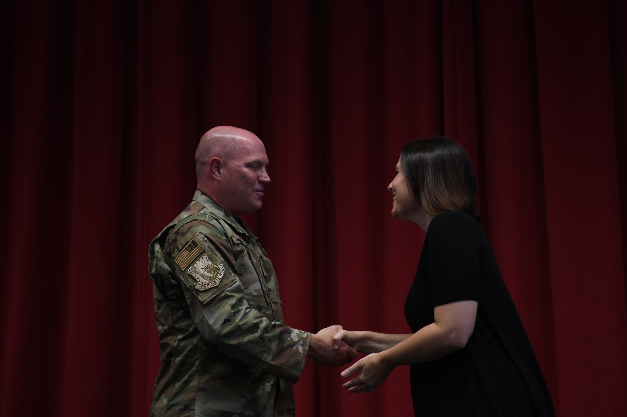 U.S. Air Force Col. John Stratton, 48th Fighter Wing vice commander, welcomes a new teacher to the Liberty Wing school community during a forum at Royal Air Force Lakenheath, England, Aug. 29, 2019. Wing leadership had the opportunity to welcome new educators to RAF Lakenheath and RAF Feltwell and share tri-base updates, congratulatory remarks, and execute a coining ceremony to commemorate their induction into the Liberty Wing family. (U.S. Air Force photo by Airman 1st Class Shanice Williams-Jones)