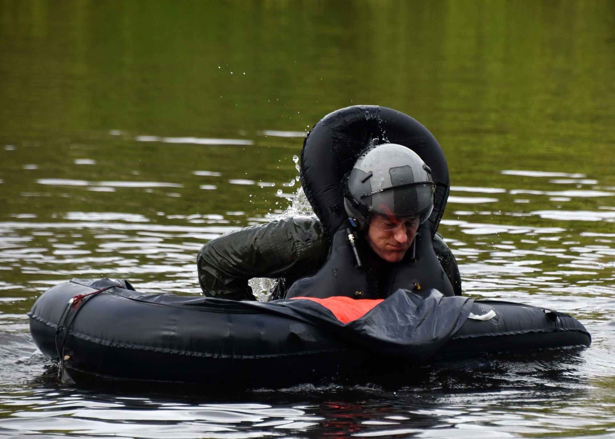 Pilot practices getting into a rescue raft during water survival training