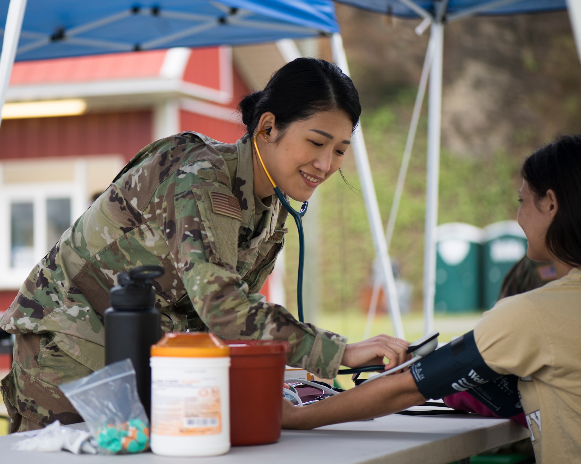 Senior Airman checks a patient's blood pressure