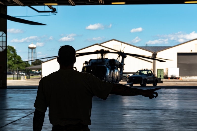 An Airman assigned to the 723d Aircraft Maintenance Squadron guides a tow truck into a hangar Aug. 30, 2019, at Moody Air Force Base, Ga. All Moody aircraft were hangared or secured in anticipation of Hurricane Dorian. (U.S. Air Force photo by Airman 1st Class Hayden Legg)
