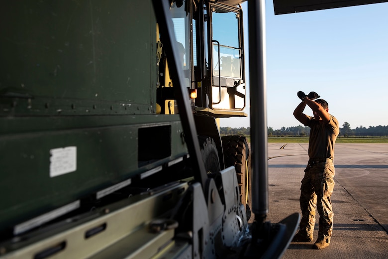 Senior Airman Jarrod Arroyo, 71st Rescue Squadron loadmaster, guides equipment into an HC-130J Combat King II Aug. 30, 2019, at Moody Air Force Base (AFB), Ga. The aircraft was used to transport personnel and equipment to Little Rock AFB, Ark. in support of Hurricane Dorian aircraft relocation efforts. (U.S. Air Force photo by Senior Airman Erick Requadt)