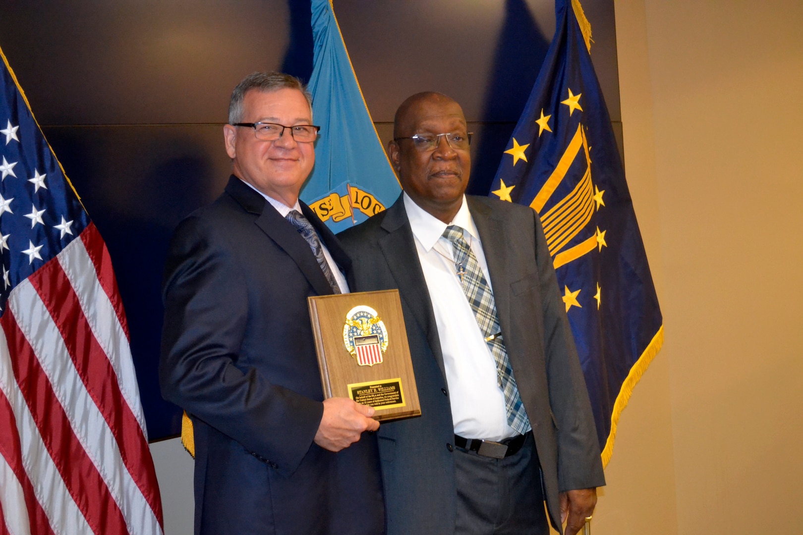 Defense Logistics Agency Troop Support Deputy Commander Richard Ellis, left, presents new retiree Stanley Williams with a plaque upon his retirement from the agency during a ceremony on Aug. 29, 2019 in Philadelphia. He retired after 32 years of service to the agency.