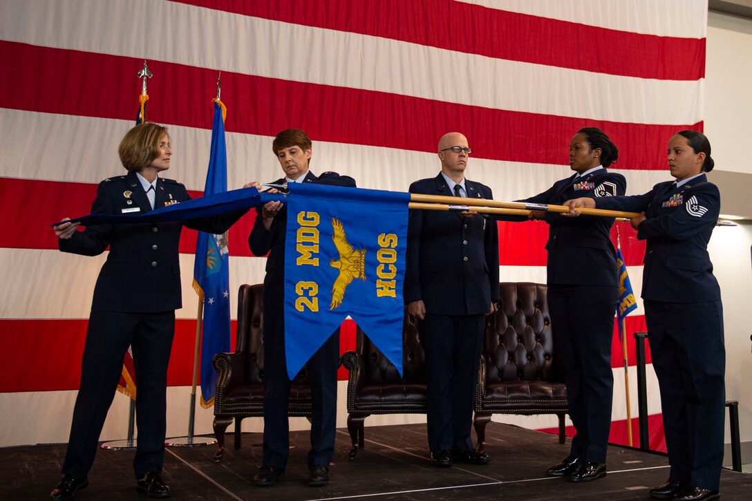 Col. Tiffany Morgan, 23d Medical Group commander, covers the 23d Medical Operations Squadron guidon during a redesignation ceremony, Aug. 30, 2019, at Moody Air Force Base, Ga. The redesignation ceremony marked the transition of both the 23d Aerospace Medicine Squadron to the 23d Operational Medical Readiness Squadron and the 23d Medical Operations Squadron to the 23d Healthcare Operations Squadron. The redesignation was part of an  Air Force-wide medical transformation directive to provide more effective and efficient ways to care for Team Moody Airman and restore squadron readiness to execute the mission.  (U.S. Air Force photo by Airman Azaria E. Foster)