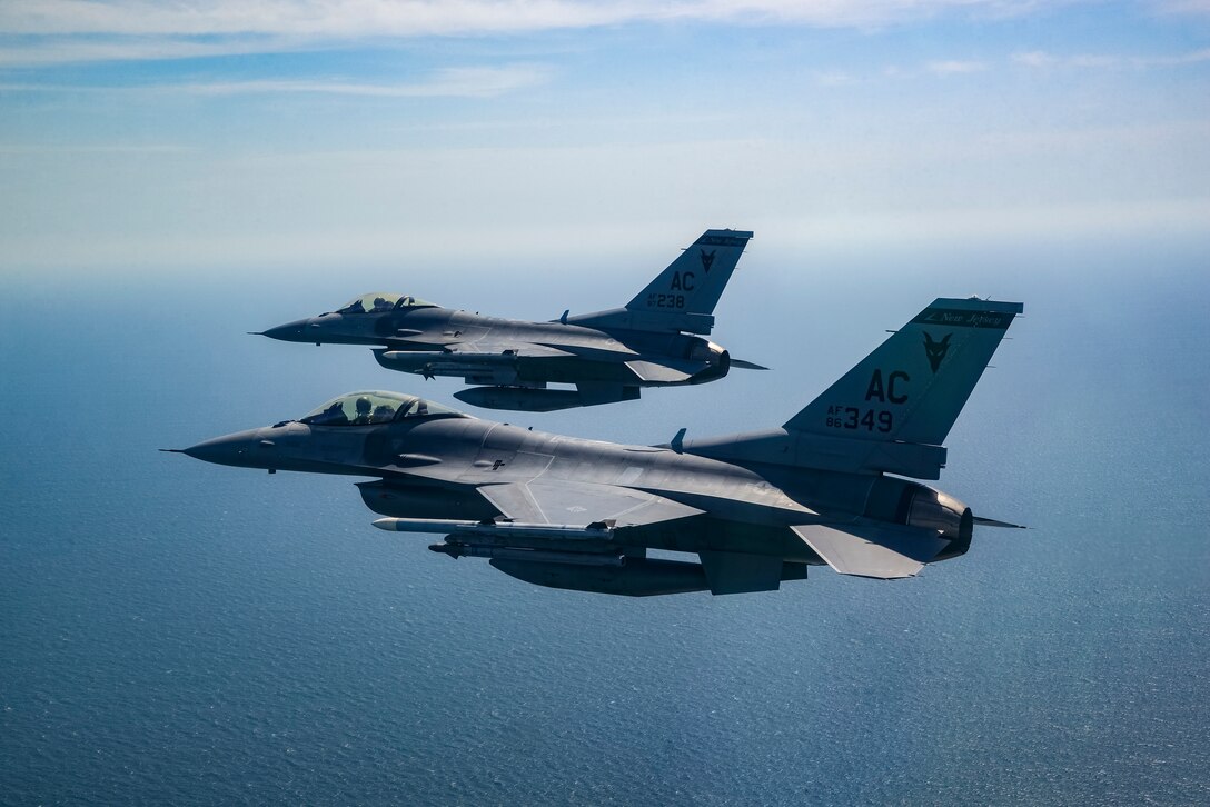 A picture of two 177th Fighter Wing F-16C and D Fighting Falcons flying over the Atlantic Ocean.