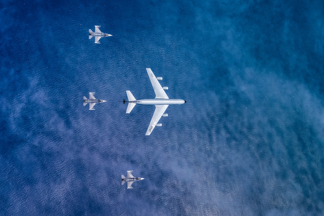 A picture of an aerial view of a KC-135 Stratotanker military refueling aircraft from the 108th Wing and three 177th Fighter Wing F-16C Fighting Falcons.