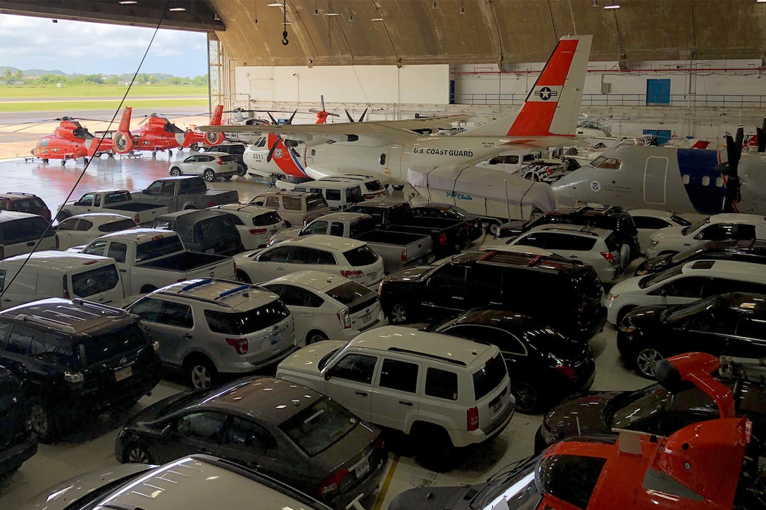 Vehicles are parked in a hangar.