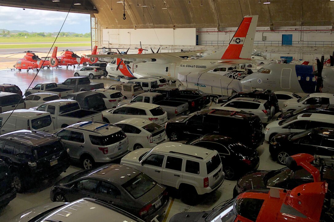 Vehicles are parked in a hangar.