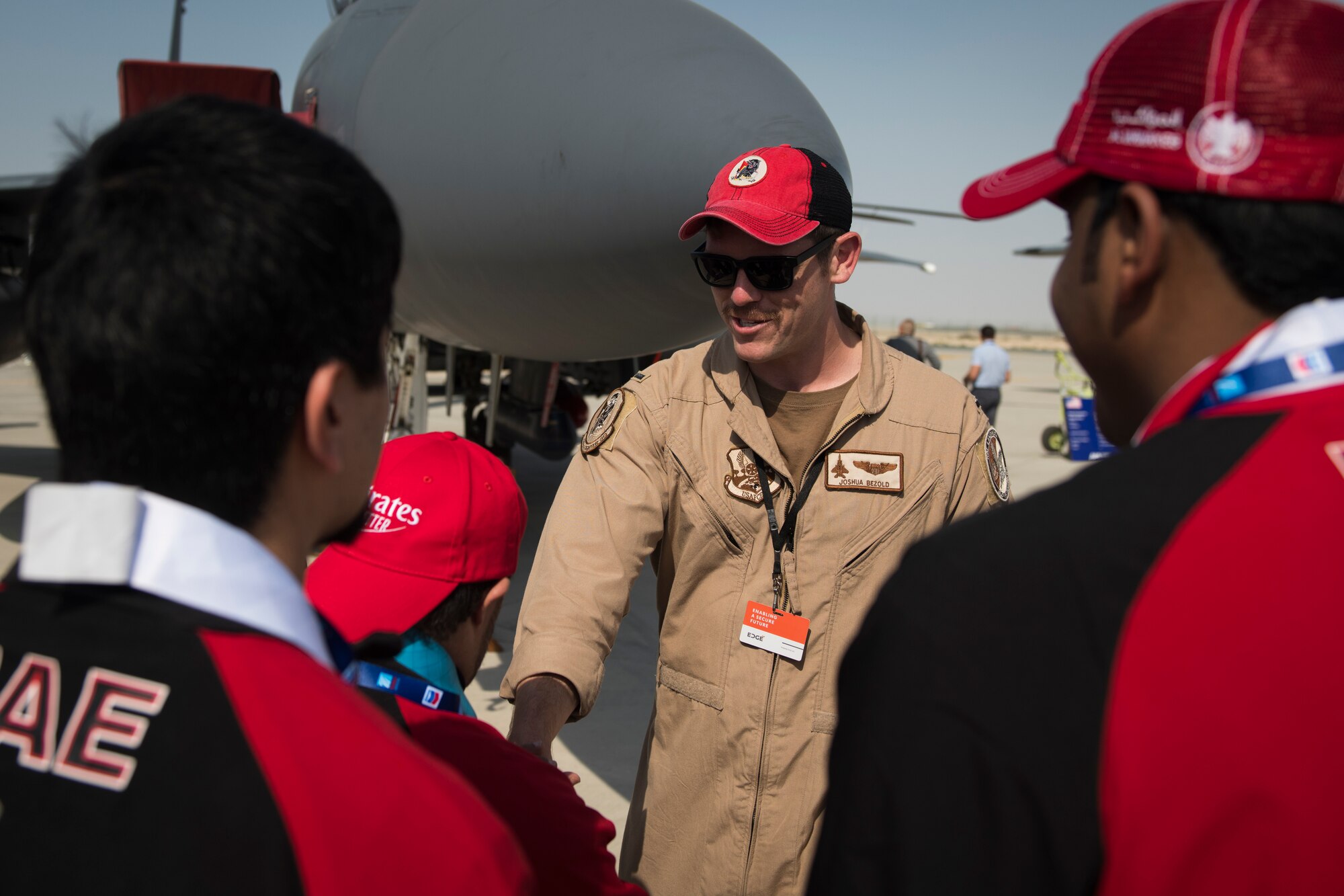U.S. Air Force 1st Lt. Joshua Bezold, an F-15E Strike Eagle pilot with the 494th Fighter Squadron, greets a member of the United Arab Emirates Special Olympics team at the Dubai Airshow, United Arab Emirates, Nov. 18, 2019.