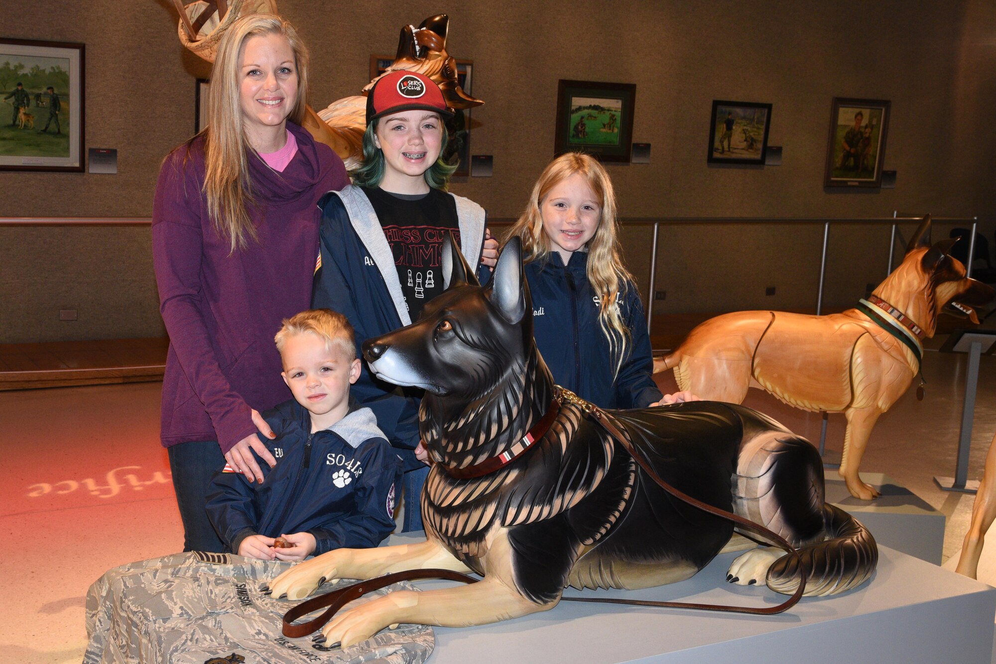 Erin Simpson and family stand with wooden sculpture of their dog Robson at the National Museum of the USAF.
