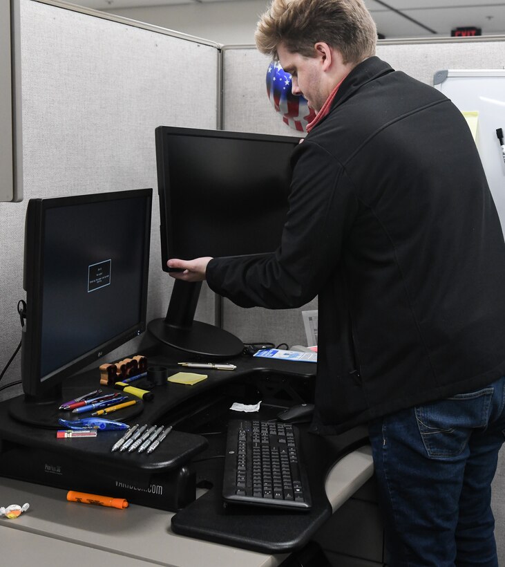 Alex Baggett, a computer network technician with the Arnold Engineering Development Complex Base Communications and Information Technology Services contractor, OBXTek, installs a new monitor, left, for a Test Operations and Sustainment contract design engineer Nov. 14, at Arnold Air Force Base. The new monitor is larger with a higher resolution, which directly improves work ability. (U.S. Air Force photo by Jill Pickett)