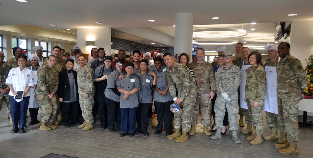 DLA Troop Support Commander Army Brig. Gen. Gavin Lawrence, far right, poses with senior leaders assigned to the 87th Force Support Squadron, Joint Basie McGuire-Dix-Lakehurst, and dining facility staff pose for a photo, before serving the traditional Thanksgiving meal Nov. 28, 2019, at the Halverson Hall Dining Facility, Joint Base McGuire-Dix-Lakehurst, New Jersey. The staff of the Halverson Hall Dining Facility provided the traditional Thanksgiving meal for airmen and their families who were away from home for the holiday. (Photo by Alexandria Brimage-Gray)