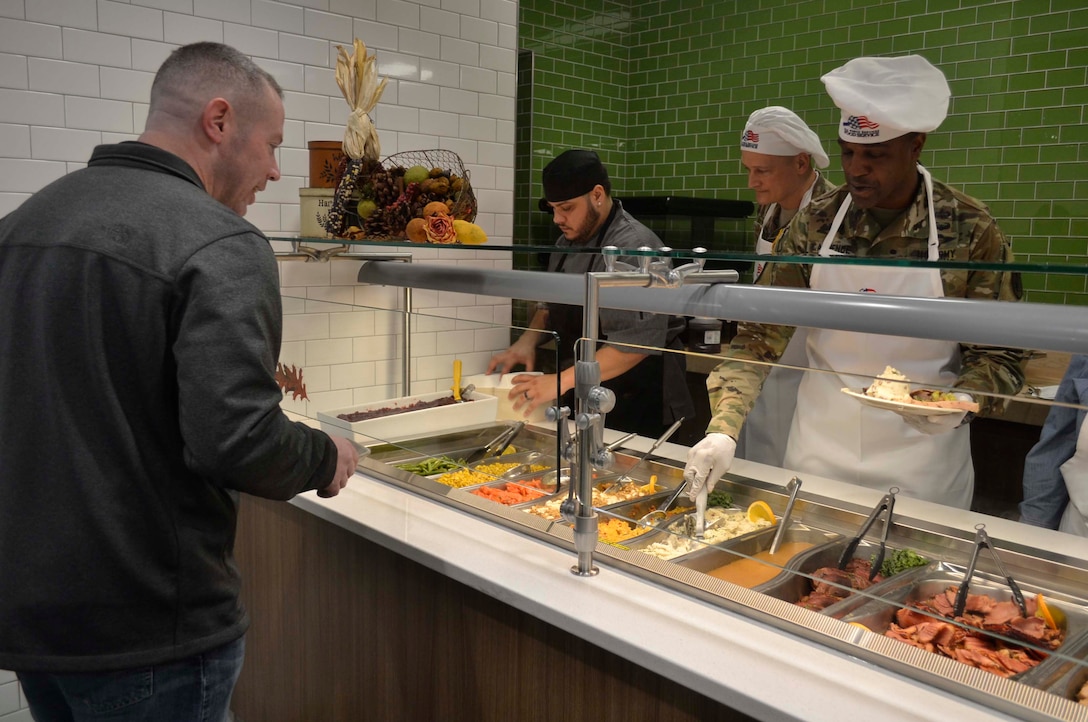 Army Brig. Gen. Gavin Lawrence, DLA Troop Support commander, far right, serves an airman a traditional Thanksgiving meal, Nov. 28, 2019, at the Halverson Hall Dining Facility, Joint Base McGuire-Dix-Lakehurst, New Jersey. Lawrence, along with senior leaders assigned to the 87th Force Support Squadron and their spouses, served meals to airmen and their families who were away from home for the holiday. (Photo by Alexandria Brimage-Gray) (Photo by Alexandria Brimage-Gray)