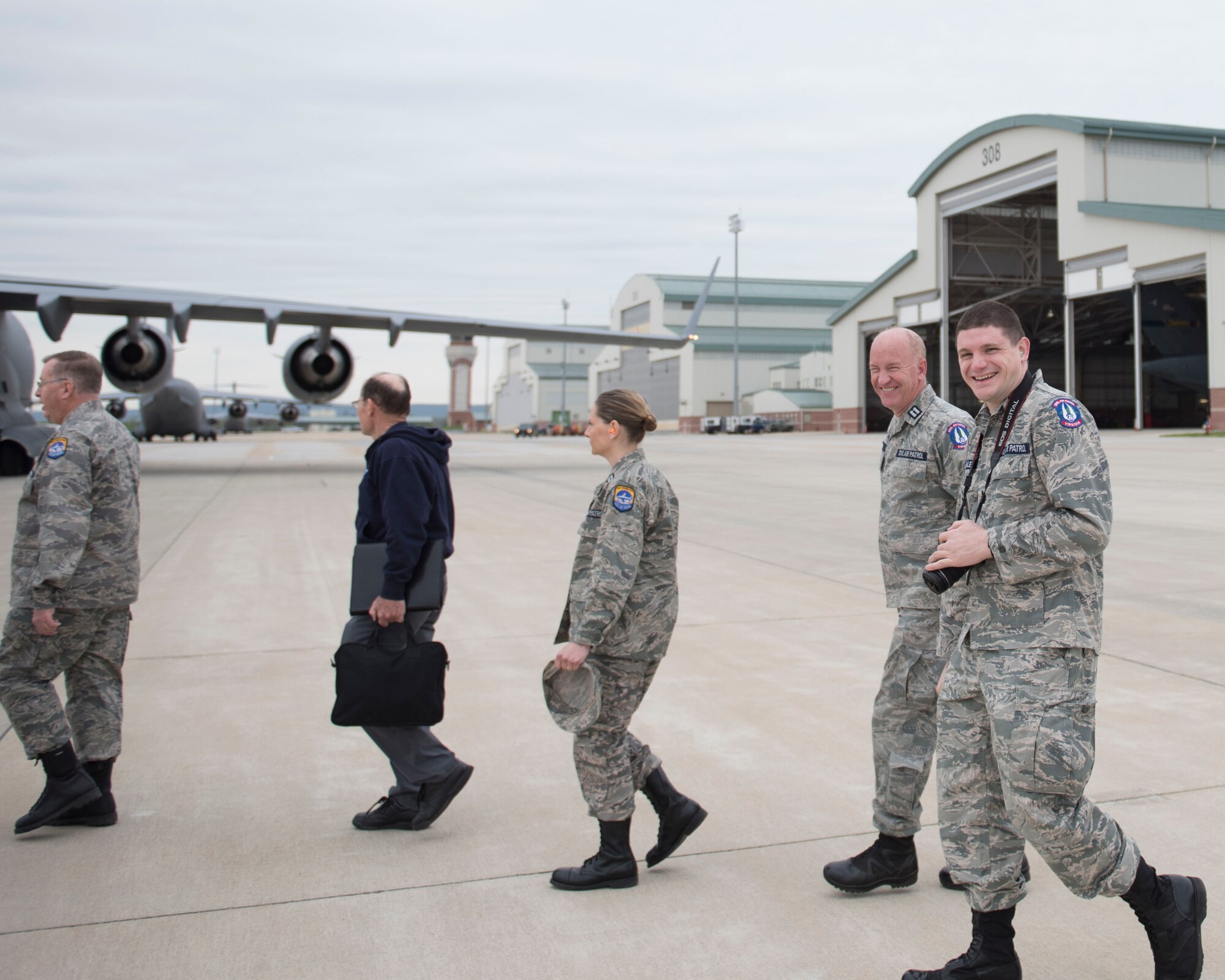 Civil Air Patrol Maj. Jacob Bixler, far right, walks across the flight line to a C-17 Globemaster III aircraft with fellow CAP members, at the 167th Airlift Wing, West Virginia Air National Guard, May 17, 2019, as part of an orientation flight. Bixler is the Wing Director of Cadet Programs for Virginia Wing, CAP. He is also a radio frequency transmissions systems craftsman for the 167th AW