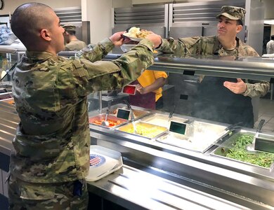 Col. Jason Janaros, commander, 37th Training Wing, passes a full plate of Thanksgiving goodies to an Airman in basic training at Joint Base San Antonio-Lackland Nov. 28.