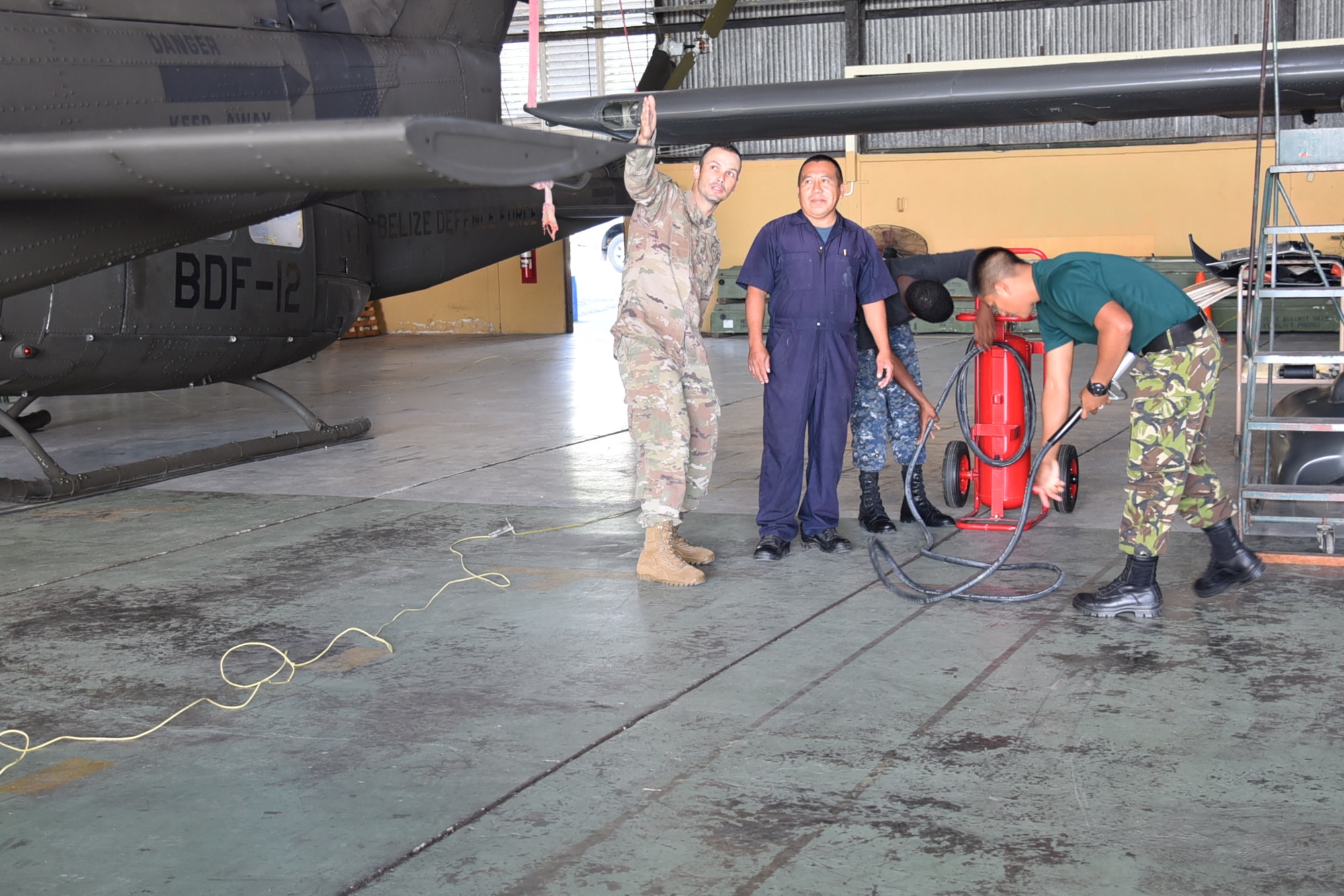 Master Sgt. Raphael Romero, 571st Mobility Support Advisory Squadron aircraft maintenance senior air advisor, discusses the aircraft parking plan with Belizean Airmen at Ladyville, Belize. The training included both classroom instruction and hands on demonstrations utilizing the BDF-AW’s personnel, aircraft, and equipment. (Courtesy Photo)