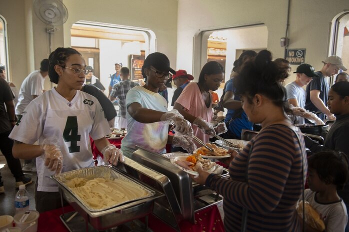 Lt. Klint Johnson, a chaplain assigned to the submarine tender USS Frank Cable (AS 40), picks up trash at the Salvation Army's annual Thanksgiving feast to provide free meals for the Guam community at Chamorro Village,