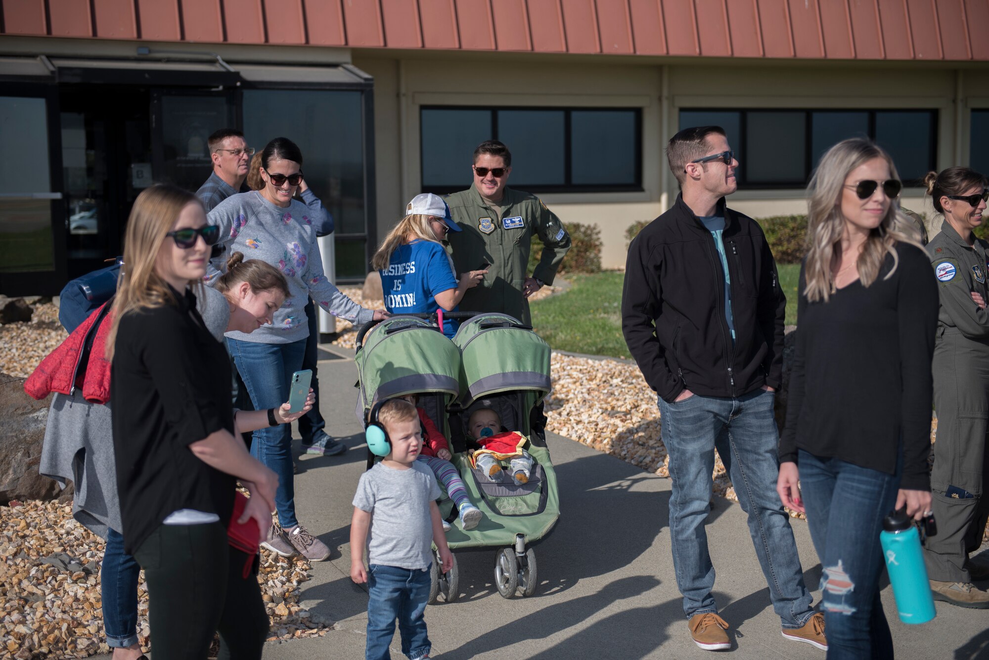 As a KC-10 Extender comes in for a landing family members and loved ones wait near the flightline to greet returning deployers Nov. 21, 2019, at Travis Air Force Base, California. The KC-10 aircrew returned to Travis AFB for the holidays after supporting operations in Southwest Asia for two months. (U.S. Air Force photo by Airman 1st Class Cameron Otte)