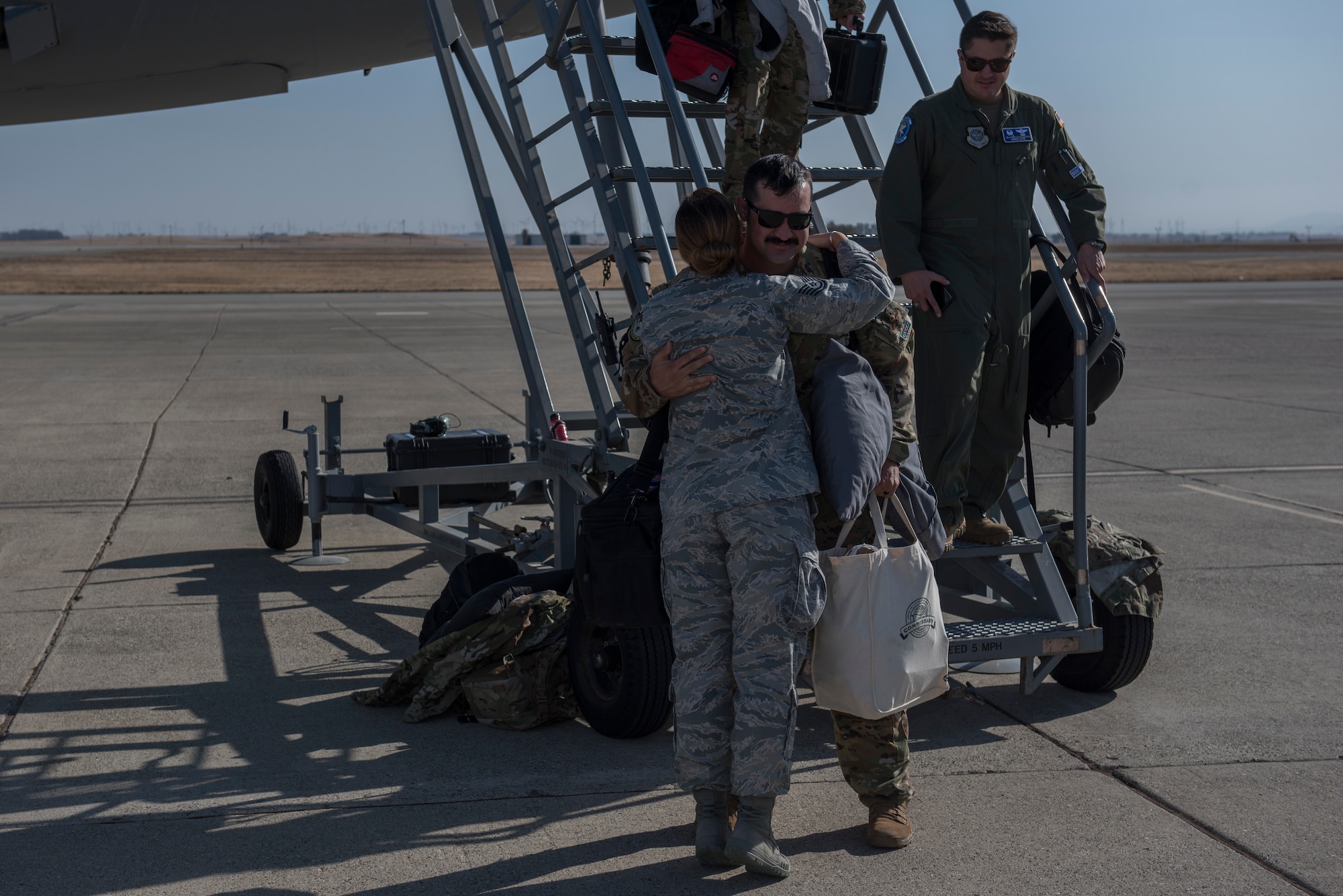 U.S. Air Force Tech. Sgt. Scott Appleby, 9th Air Refueling Squadron boom operator, embraces Tech. Sgt. Traci Keller, 60th Air Mobility Wing Public Affairs command information noncommission officer in charge, Nov. 21, 2019, at Travis Air Force Base, California. Scott was part of a KC-10 aircrew that supported operations in Southwest Asia for two months. (U.S. Air Force photo by Airman 1st Class Cameron Otte)
