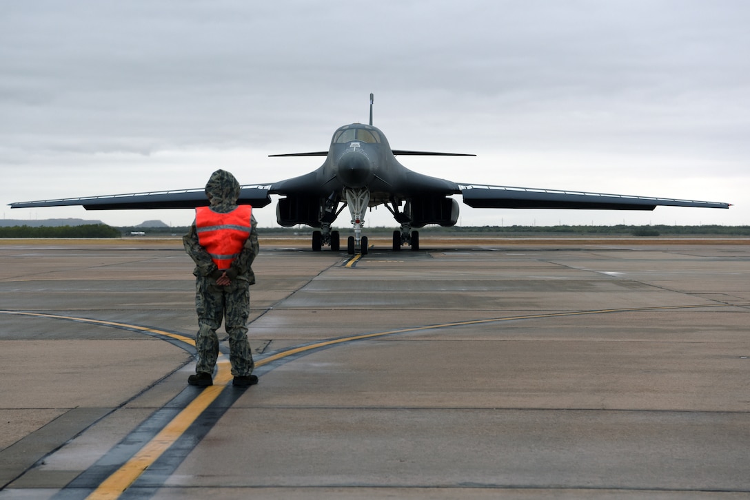 Crew chief marshalls B-1B Lancer aircraft