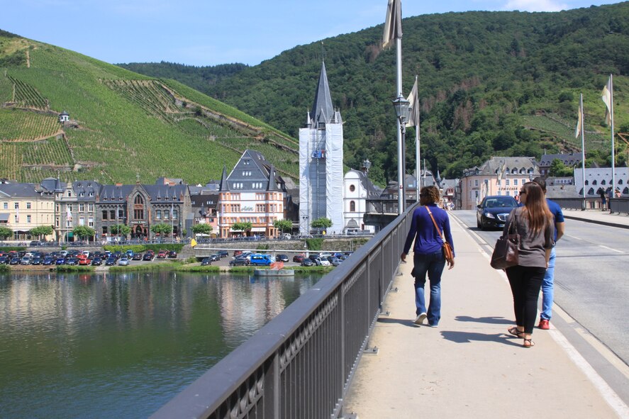 A photo of people walking along a bridge.