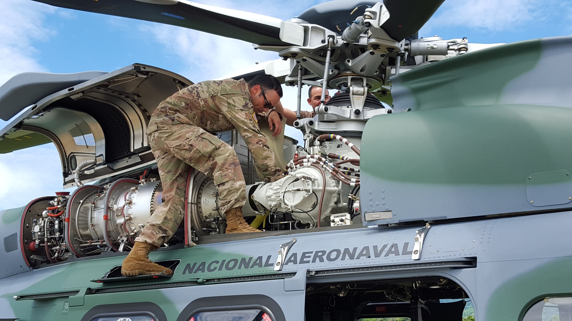 Master Sgt. Raphael Romero, 571st Mobility Support Advisory Squadron aircraft maintenance senior air advisor, performs a post-flight inspection on an Augusta Westland AW-139 helicopter engine along with the National Air and Naval Service of Panama flying crew chief at Nicanor Air Base, Panama. Air advisors assess, train, advise and assist U.S. Southern Command lines of effort of strengthening partnerships and countering threats from transnational criminal organizations. (Courtesy Photo)