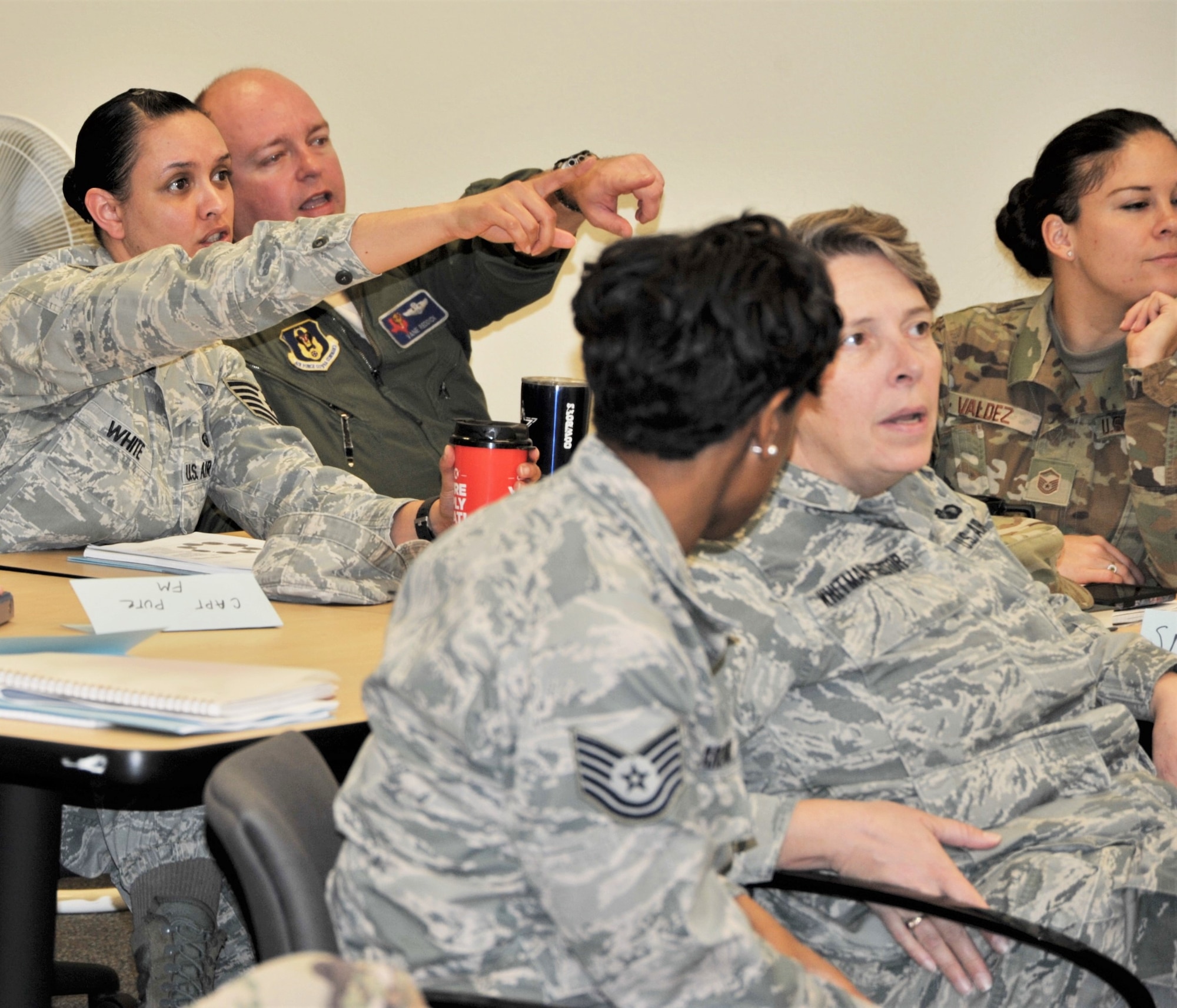 Tech. Sgt. Janina White, 340th Flying Training Group force management non-commissioned officer in charge and Lt. Col. Thad Reddick, 39th Flying Training Squadron instructor pilot, hone in on a point during the Nov. 19-21 continuous process improvement event at Joint Base San Antonio-Randolph, Texas, as group members (left to right) Tech. Sgt. Ecstacy Hardaway (right), Senior Master Sgt. Amy Whitman-Rector and Master Sgt. Valerie Valdes listen in during a discussion on the best way to solve issues that occur when Reserve members transition between pay statuses. (U.S. Air Force photo by Debbie Gildea)