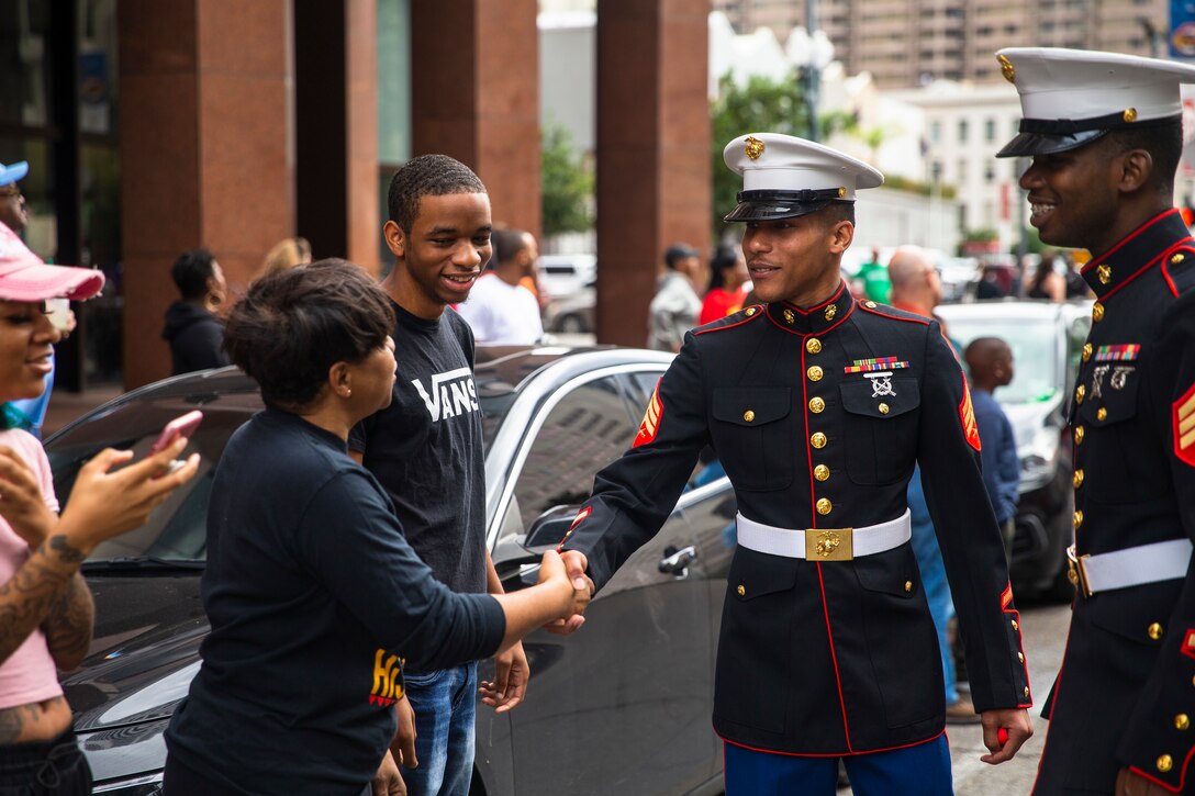 Sergeant Javan William (center),  and Sgt. Tyraus Gayle, both recruiters with Marine Corps Recruiting Station Baton Rouge, engage with spectators during the Bayou Classic Parade at the 46th Annual Bayou Classic in New Orleans, Louisianam November 30, 2019. Through a partnership with Bayou Classic, the Marines are looking to engage students and their influencers to influence them toward service as United States Marine. The Bayou Classic was founded in 1936 and is a game between Southern University and Grambling State University. This year marks the 19th anniversary of the Marine Corps' partnership with Bayou Classic. (Marine Corps photo by Cpl. Haley Mathers)